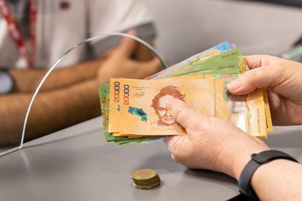 Costa,Rica,Money,,A,Woman,Stands,At,The,Cash,Register
